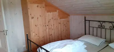 a bedroom with a bed in a wooden wall at Beitostølen Hytter in Beitostøl