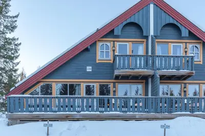 a log home with a large deck in the snow at Bakkebyvegen 22B in Trysil