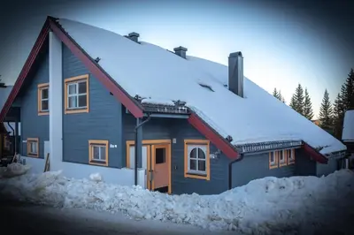 a blue house with snow on the roof at Bakkebyvegen 22B in Trysil
