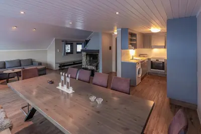 a kitchen and living room with a wooden table and chairs at Bakkebyvegen 22B in Trysil