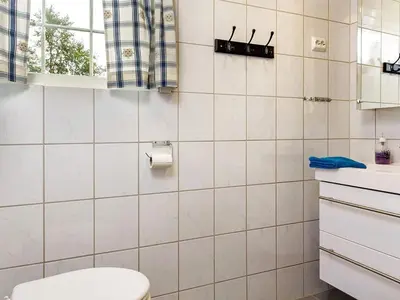 a white tiled bathroom with a toilet and a window at 7 person holiday home in Hemsedal-By Traum in Hemsedal