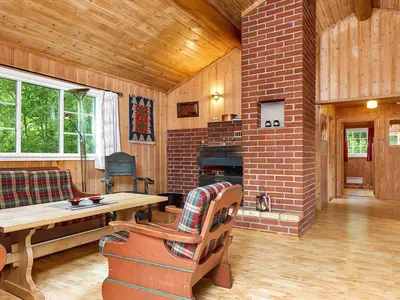 a living room with a brick fireplace and a table at 7 person holiday home in Hemsedal-By Traum in Hemsedal
