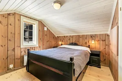a bedroom with a bed in a room with wooden walls at Gaustablikk hytta ski-in ski-out in Gaustablikk