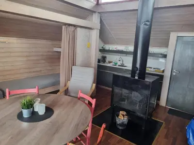 a dining room with a table and a wood stove at Kvamshaugen hytter in Luster