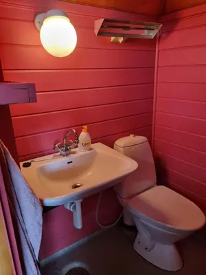 a red bathroom with a toilet and a sink at Kvamshaugen hytter in Luster
