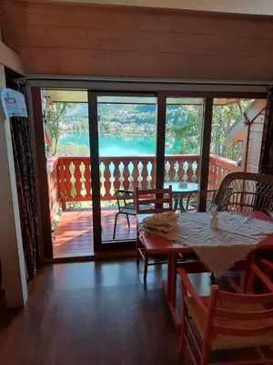 a dining room with a table and chairs and a balcony at Kvamshaugen hytter in Luster