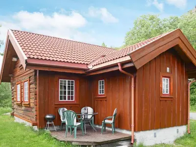 a log cabin with a table and chairs on a deck at 5 person holiday home in Hemsedal-By Traum in Hemsedal