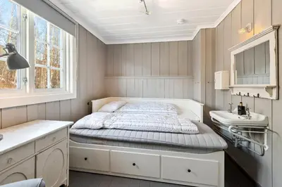 a small bedroom with a bed and a sink at Solsiden - in the center of Geilo in Geilo