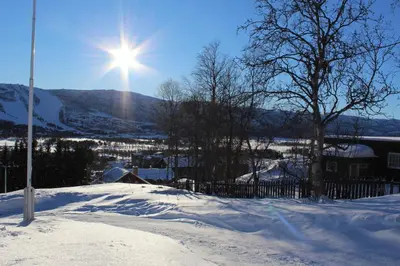 a snow covered hill with the sun in the sky at Solsiden - in the center of Geilo in Geilo