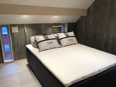 a large white bed with pillows on top of it at Robinsons Rorbu - located in Bud in Bud