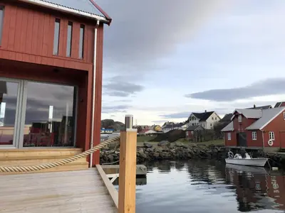 a building with a dock and a boat in the water at Robinsons Rorbu - located in Bud in Bud