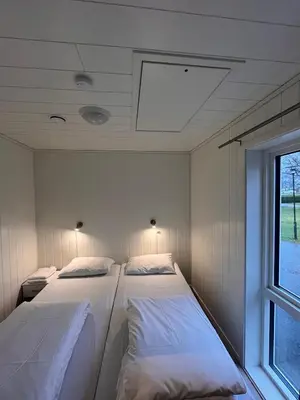 two beds in a room with a window at Kviltorp Camping in Molde
