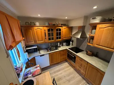 an overhead view of a kitchen with wooden cabinets at Downtown Historical House with Renovated apartments free P near in Ålesund