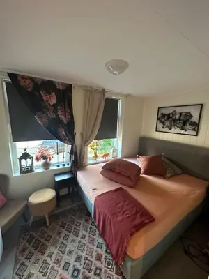 a bedroom with a large bed and a window at Downtown Historical House with Renovated apartments free P near in Ålesund