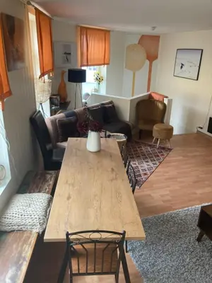 a living room with a wooden table and a couch at Downtown Historical House with Renovated apartments free P near in Ålesund