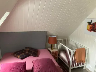 a attic bedroom with a bed and a lamp at Downtown Historical House with Renovated apartments free P near in Ålesund