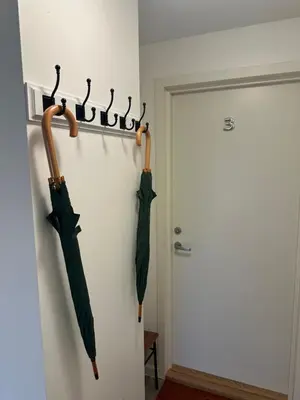 two umbrellas hanging on a wall next to a door at Downtown Historical House with Renovated apartments free P near in Ålesund