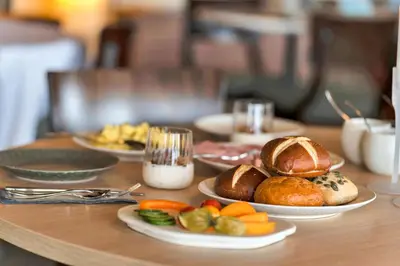 a table with plates of bread and vegetables on it at Ranten Hotell Best Western Signature Collection in Nesbyen