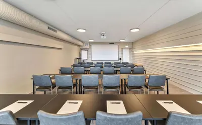 a conference room with tables and chairs and a whiteboard at Ranten Hotell Best Western Signature Collection in Nesbyen