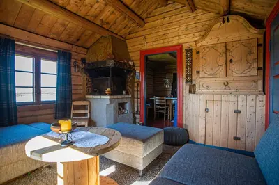 a living room with a table and a stove at Olestølen in Skammestein