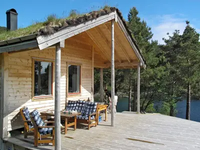 a cabin with a table and chairs on a deck at Chalet Svanöy by Interhome in Grimeli