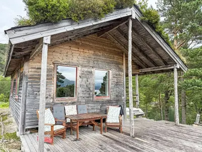 a cabin with a wooden table and chairs on a deck at Chalet Svanöy by Interhome in Grimeli