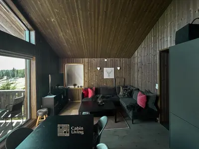 a living room with a couch and a table at Cozy Apartment electric car charger & ski in out Sjusjøen in Sjusjøen