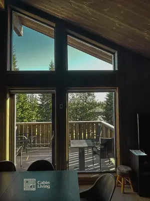 a room with a view of a deck through a window at Cozy Apartment electric car charger & ski in out Sjusjøen in Sjusjøen