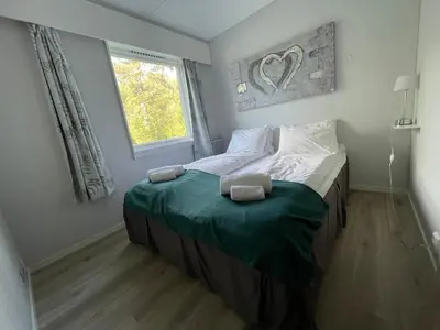 a bedroom with a bed with a green blanket and a window at Fossanåsen Hotel in Flesberg