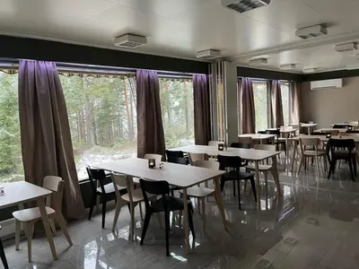 a dining room with tables and chairs and windows at Fossanåsen Hotel in Flesberg
