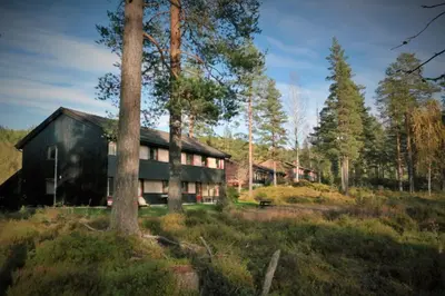 a black house in the middle of a forest at Fossanåsen Hotel in Flesberg