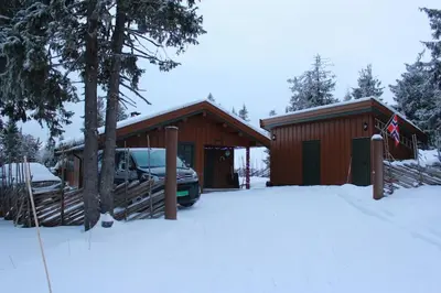 a house with a car parked in the snow at Hytte sentralt Ljøsheim, Ringsaker(nær Sjusjøen) in Ringsaker