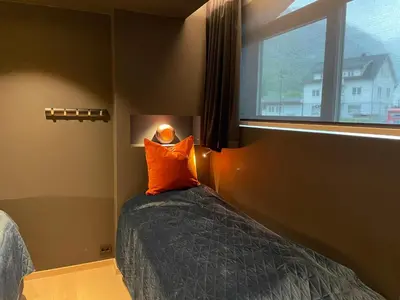 a bedroom with a bed with an orange pillow and a window at Olden apartments 2 in Stryn