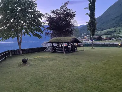 a picnic table in a field next to a lake at Olden apartments 2 in Stryn