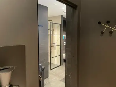 a bathroom with a toilet and a glass door at Olden apartments 2 in Stryn