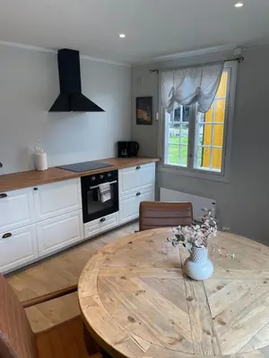 a kitchen with a wooden table and a dining room at Finnegården Røros in Røros