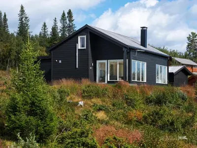 a black house sitting on top of a hill at Skarvebo - cabin with amazing view in Hol