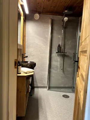 a bathroom with a shower and a sink at Stallen - koselig lite hus på gårdstun in Skjåk