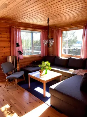 a living room with a couch and a table at Bergen/Sotra: Sea cabin. Spa. Fishing. Boat in Haganes
