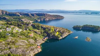 an island in the water with a yellow object on it at Bergen/Sotra:Waterfront cabin(s).Boat.Fish.Jacuzzi in Haganes