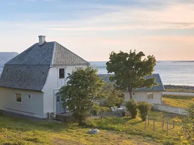 a white house on a hill next to the ocean at 5 person holiday home in Svelgen-By Traum in Svelgen