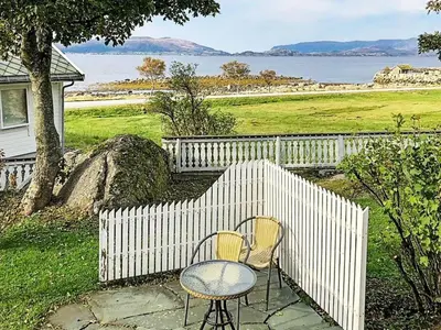 two chairs and a table next to a fence at 5 person holiday home in Svelgen-By Traum in Svelgen