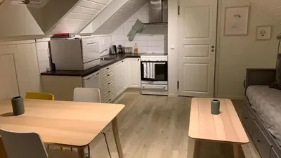 a kitchen and dining room with a table and a couch at Bright and cozy apartment 1.5km from city centre in Aurland