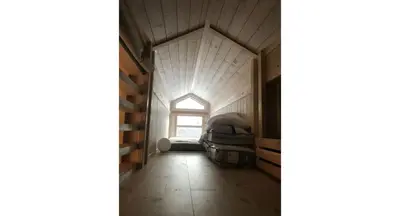 an attic bedroom with a window and a bed in a room at Venehovda - cabin at 1000 masl in Ål