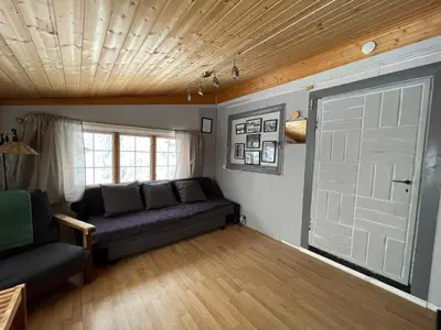 a living room with a couch and a door at Buhaug - cabin at Sjusjøen in Sjusjøen