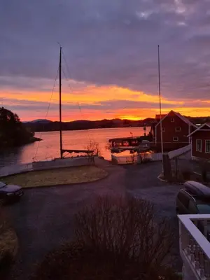 a sunset over a body of water with a sail boat at VILLA BRATTHOLMEN in Brattholmen
