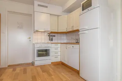 a kitchen with white cabinets and a white refrigerator at Skitorget Apartments in Trysil