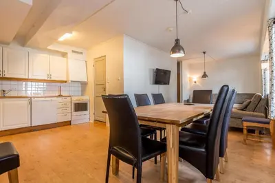 a kitchen and dining room with a wooden table and chairs at Skitorget Apartments in Trysil