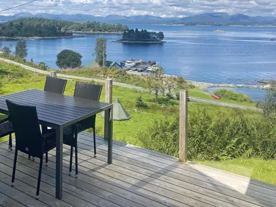a table and chairs on a deck with a view of the water at 4 person holiday home in LINDÅS-By Traum in Lindås