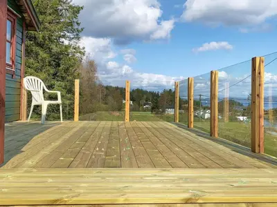 a wooden deck with a chair on a house at 4 person holiday home in LINDÅS-By Traum in Lindås